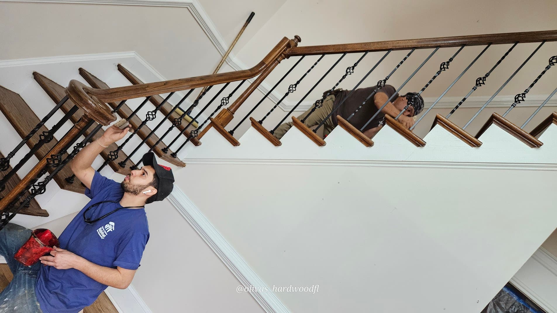 Crew finishing staircase with ornate iron balusters in Lawrenceville, GA