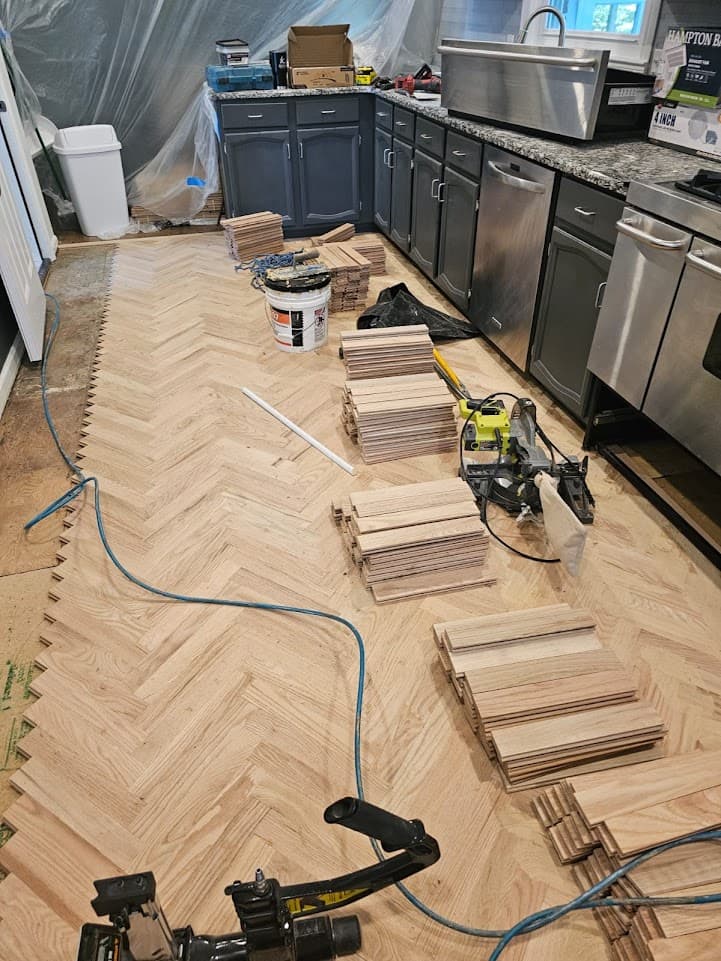Herringbone hardwood floor installation in Roswell GA — red oak planks stacked and ready for installation