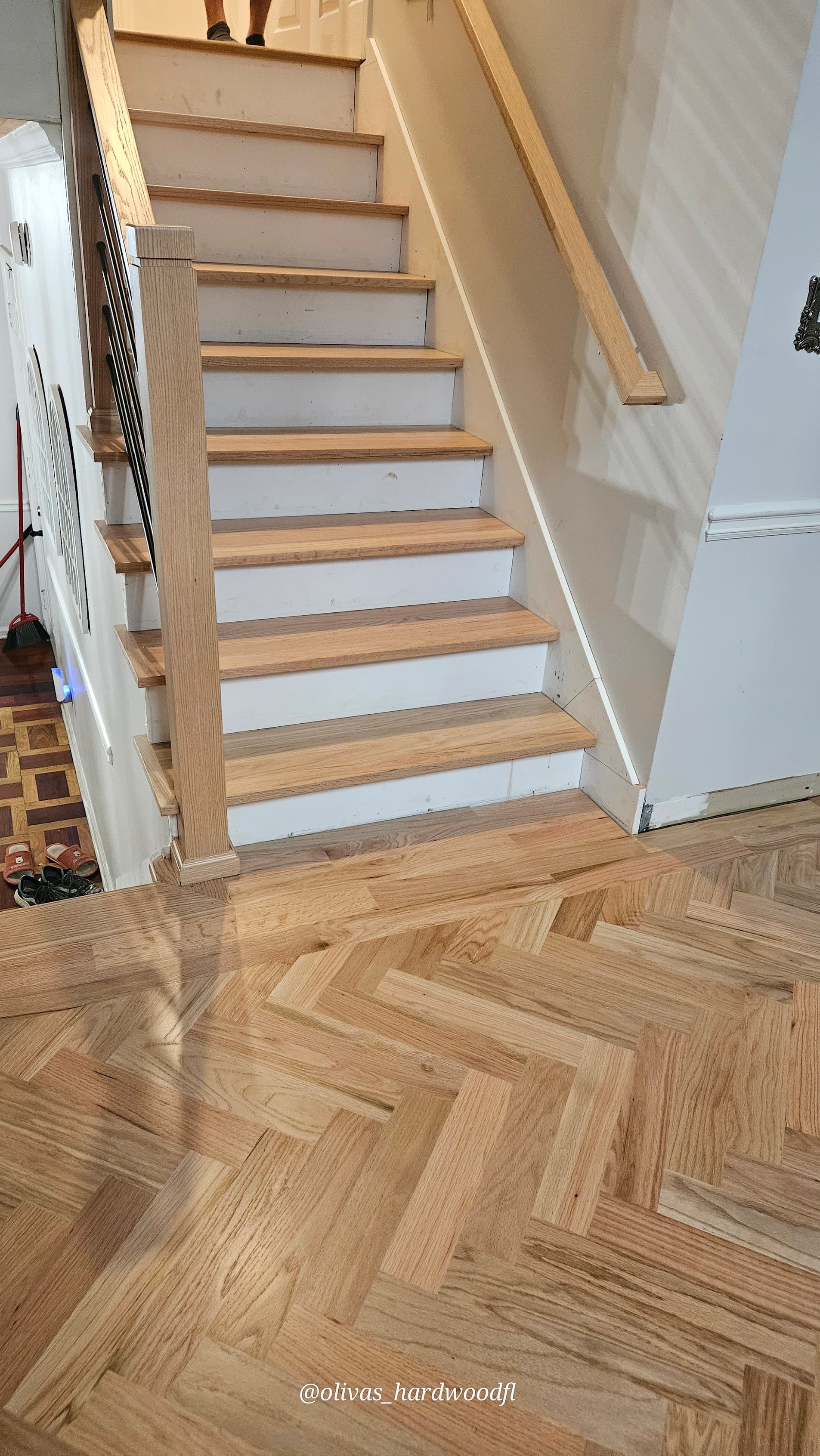 Hardwood installation in Marietta GA — natural oak staircase treads above herringbone foyer