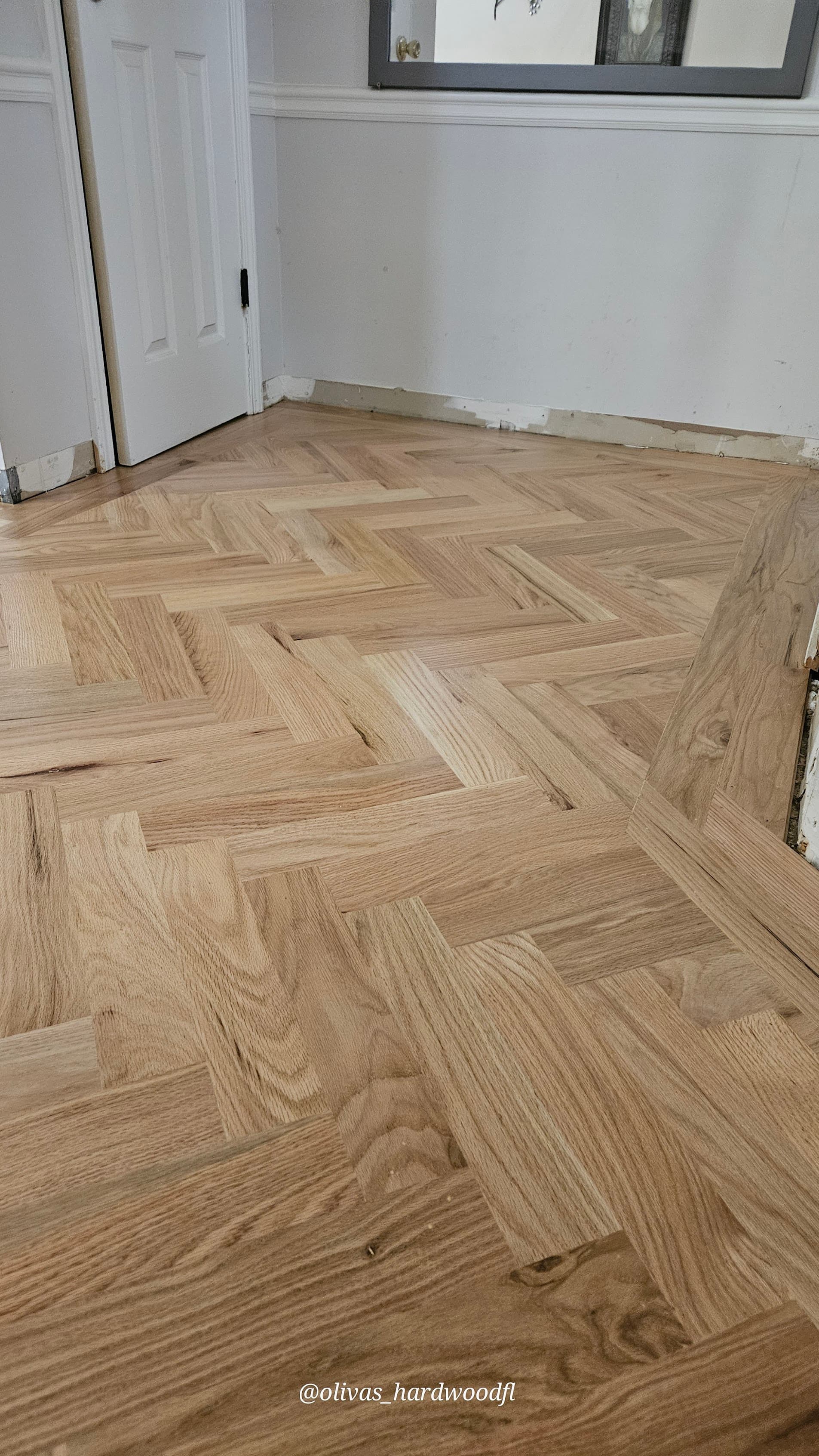 Herringbone hardwood floor installation in Atlanta GA — natural red oak hallway sanded ready for finish
