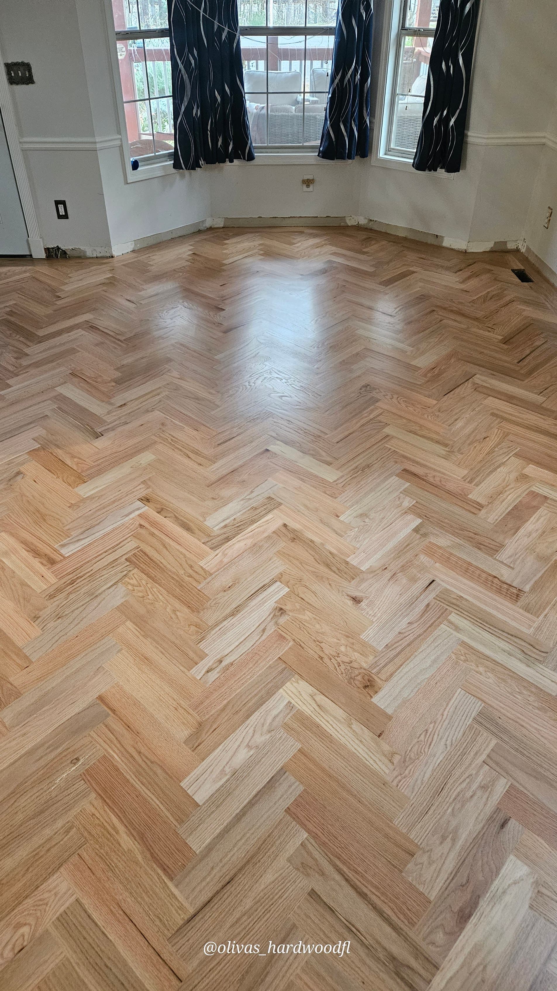 Herringbone hardwood floor installation in Lawrenceville GA — natural red oak dining room with bay window