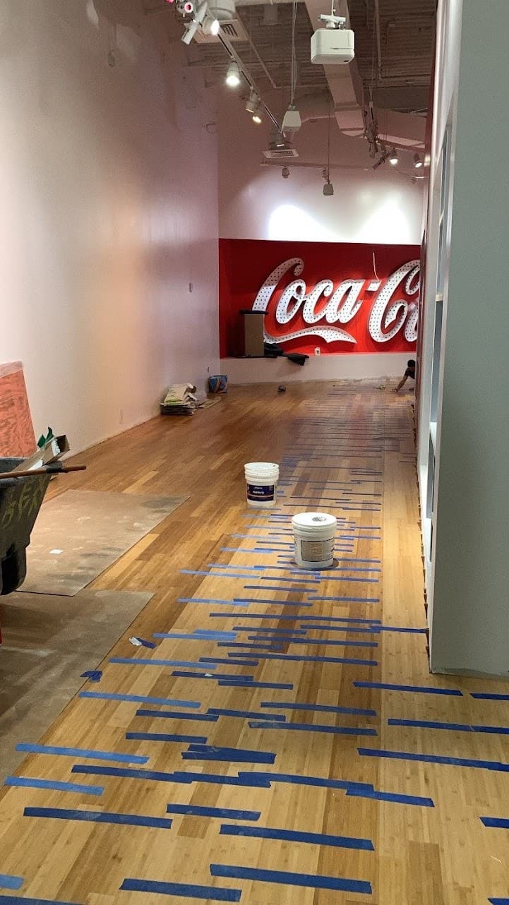 Commercial hardwood floor repair in Atlanta GA — damaged boards marked for replacement in exhibit space