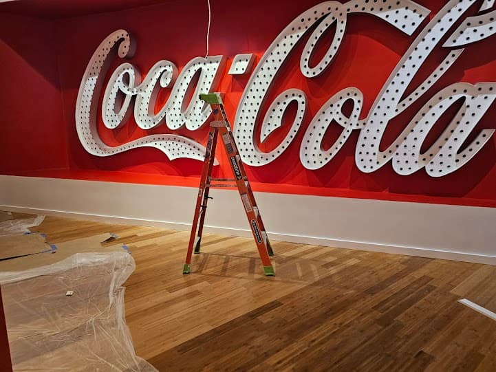 Commercial hardwood floor refinishing in Atlanta GA — exhibit space with Coca-Cola marquee sign