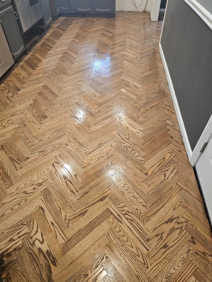 Herringbone hardwood floor refinishing in Gwinnett County GA — medium stain red oak hallway with glossy finish