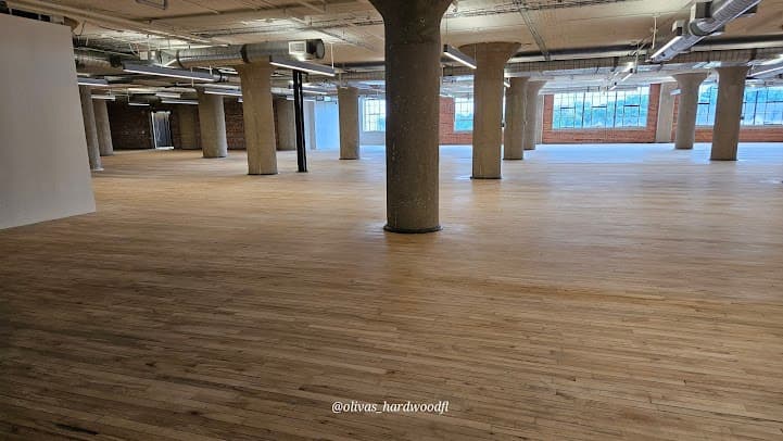 Commercial hardwood floor refinishing in Atlanta GA — natural oak with industrial windows