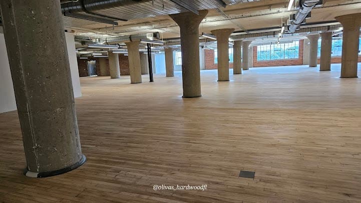 Commercial hardwood floor refinishing in Atlanta GA — wide open natural oak floor plan after professional refinishing
