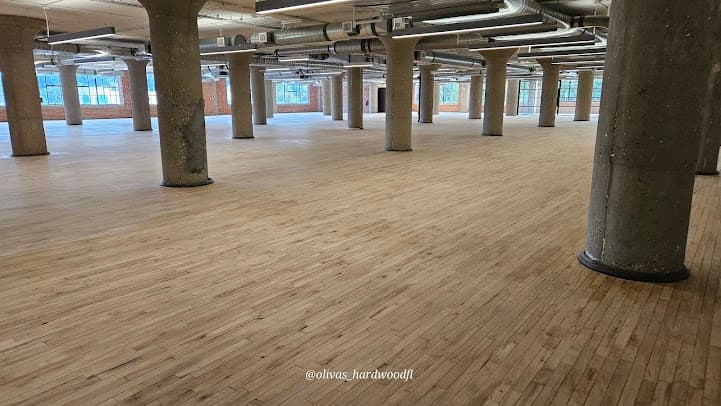 Commercial hardwood floor refinishing in Atlanta GA — large open space natural oak with concrete columns