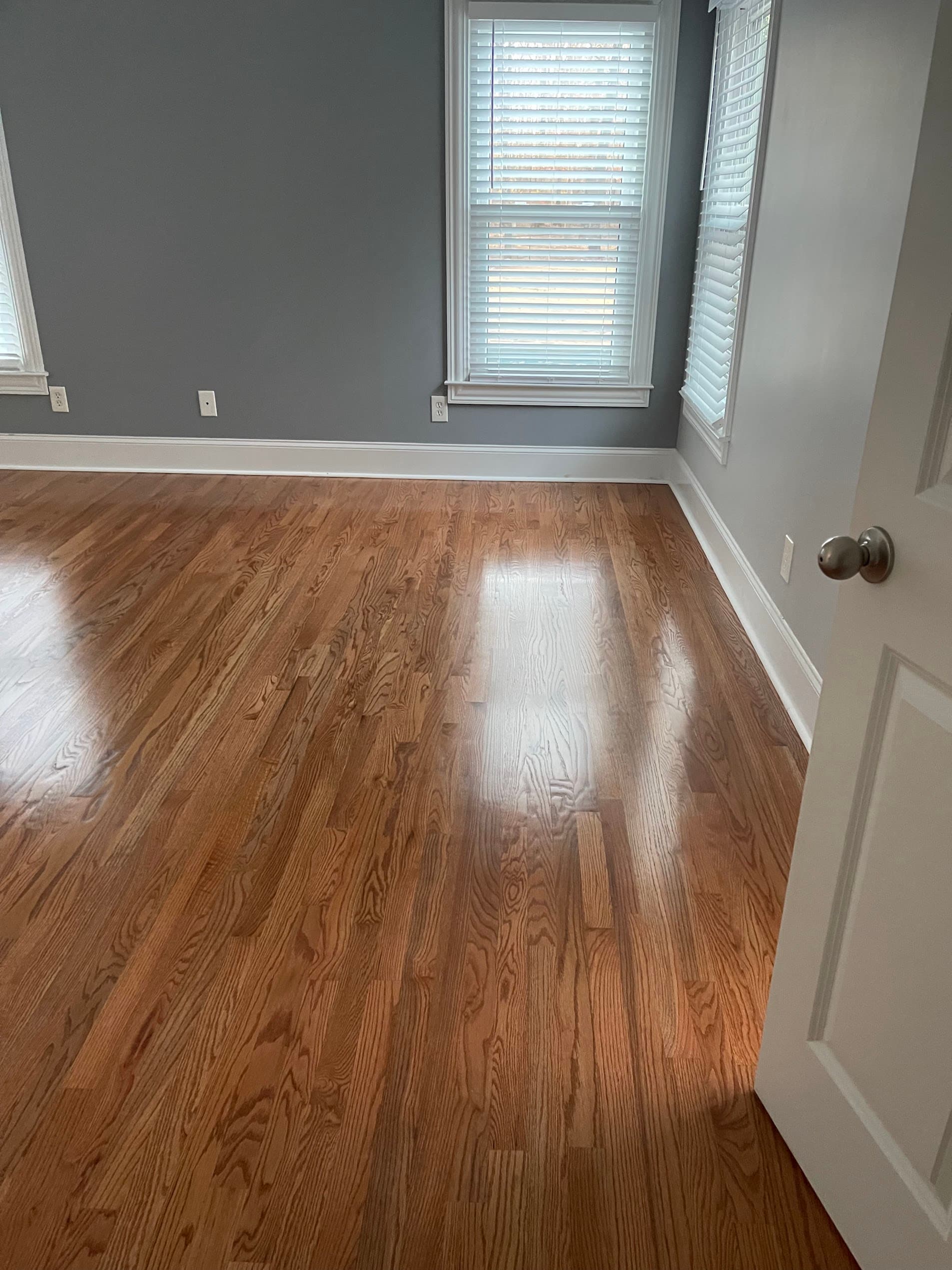Hardwood floor refinishing in Roswell GA — gunstock stain red oak bedroom with bright windows