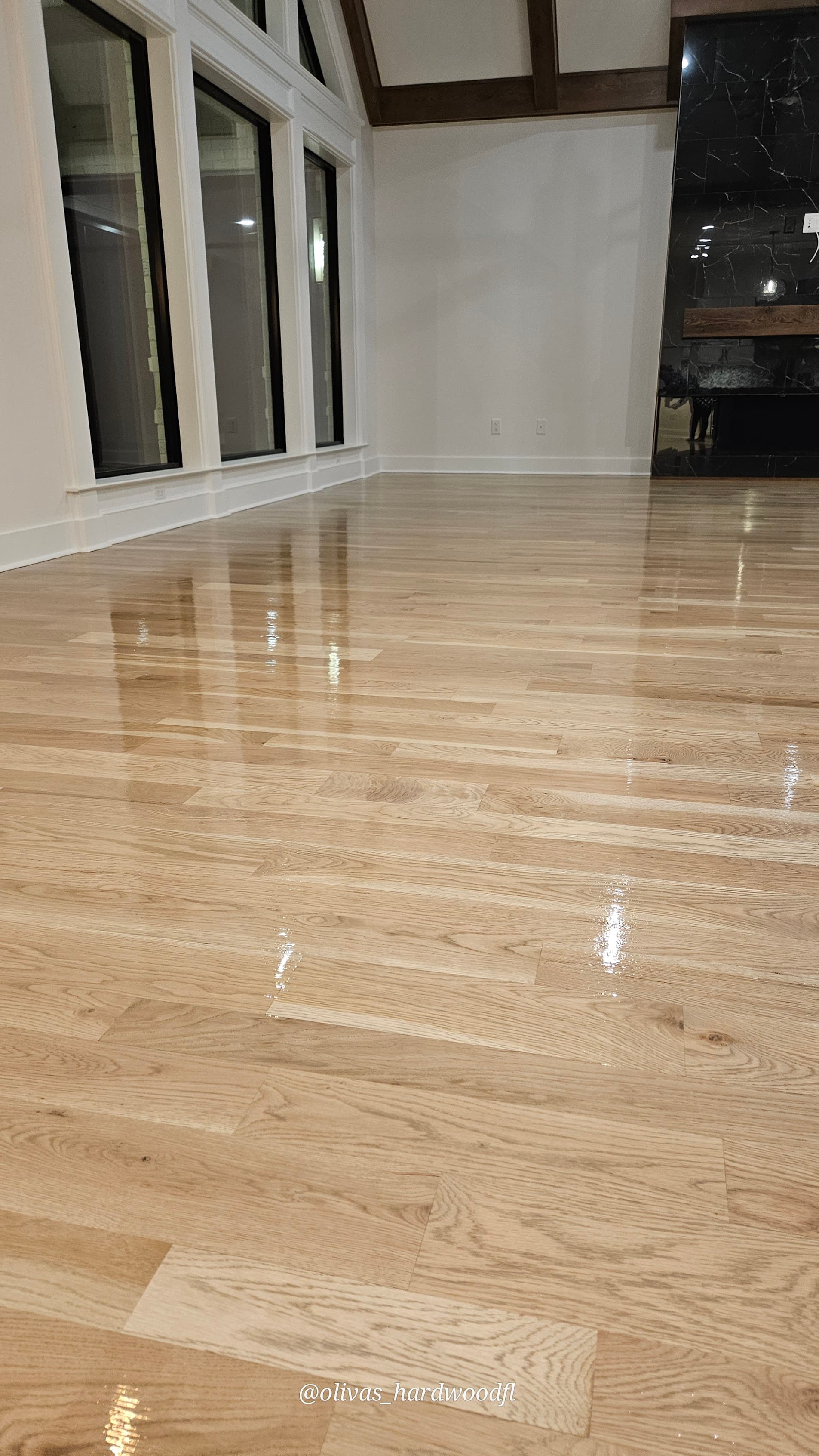 Hardwood floor refinishing in Alpharetta GA — natural white oak high-gloss living room with dark marble fireplace