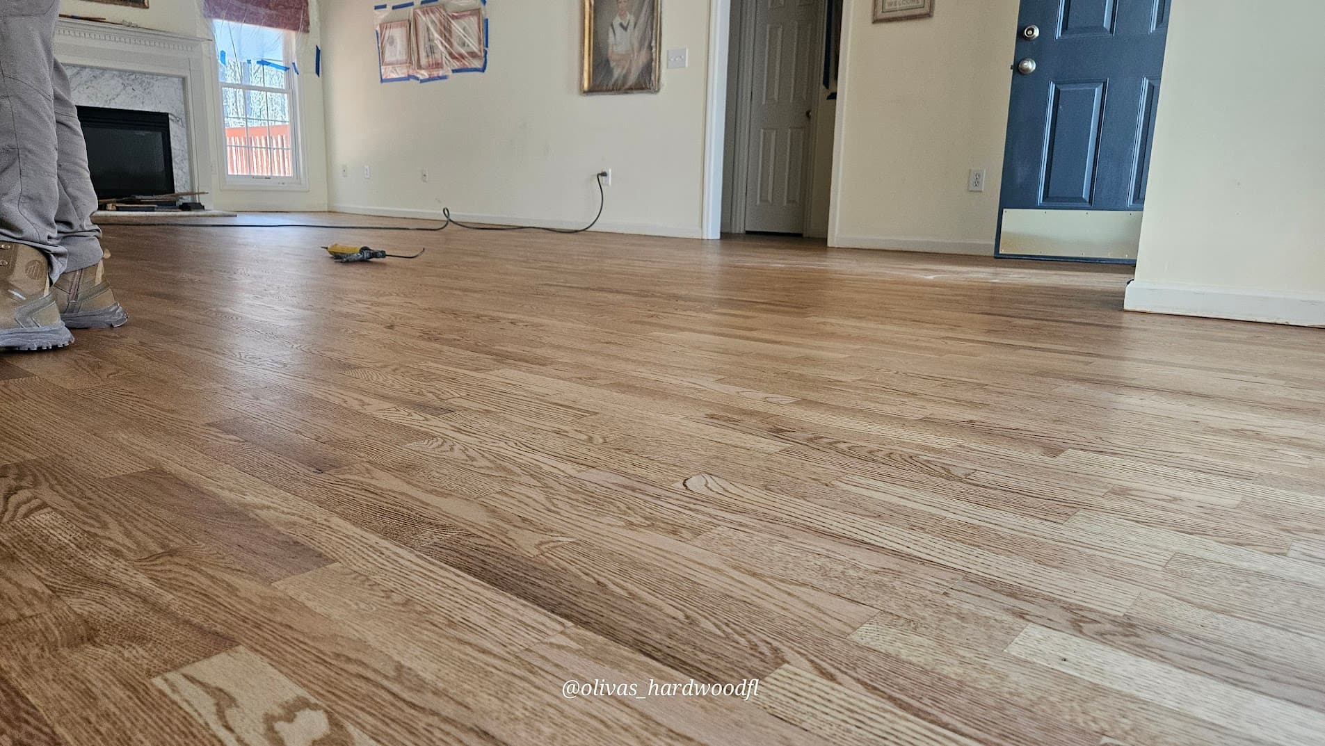 Hardwood floor refinishing in progress in Lawrenceville GA — natural oak living room mid-stain application