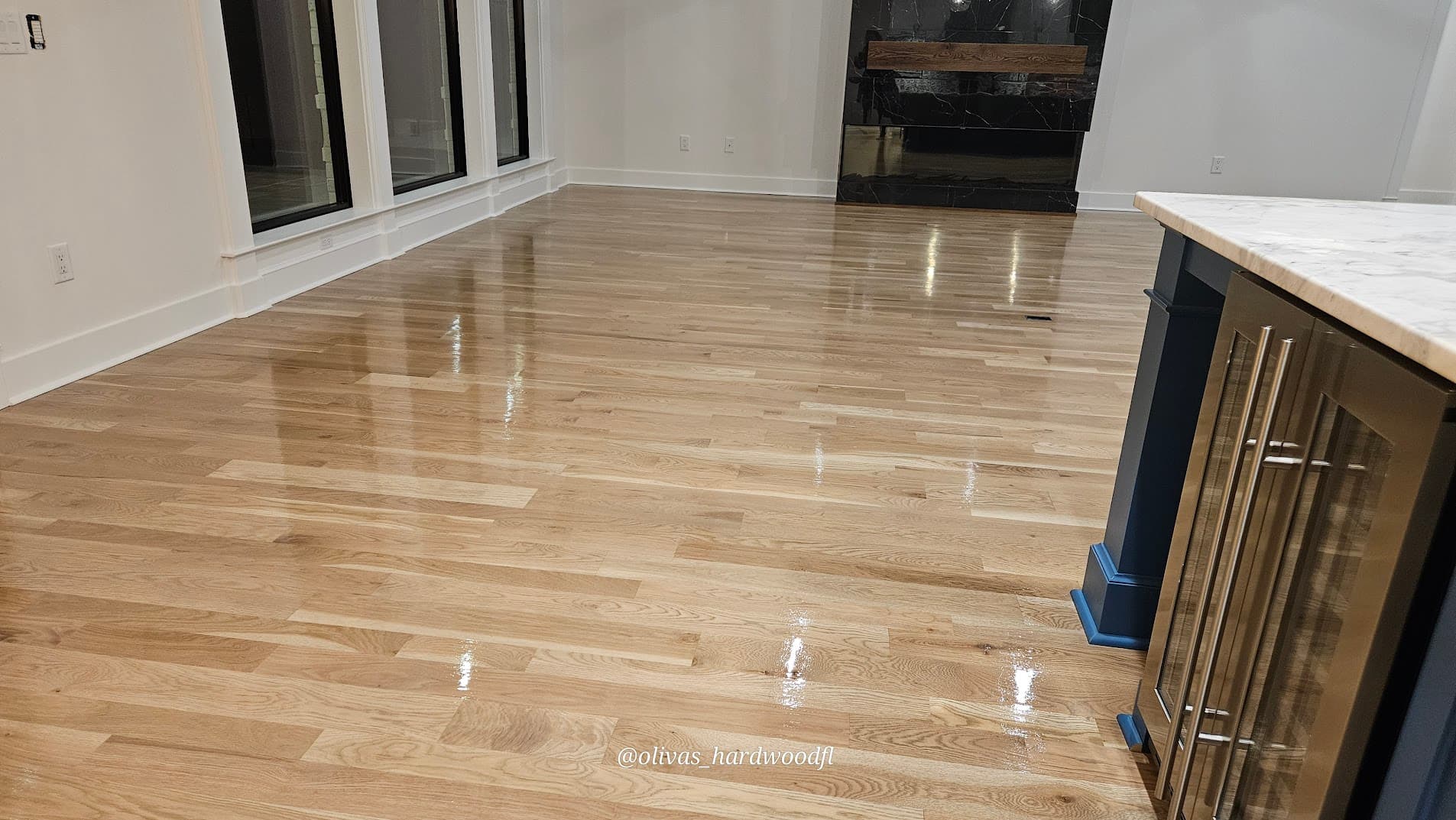 Hardwood floor refinishing in Lawrenceville GA — natural white oak high-gloss kitchen with blue island