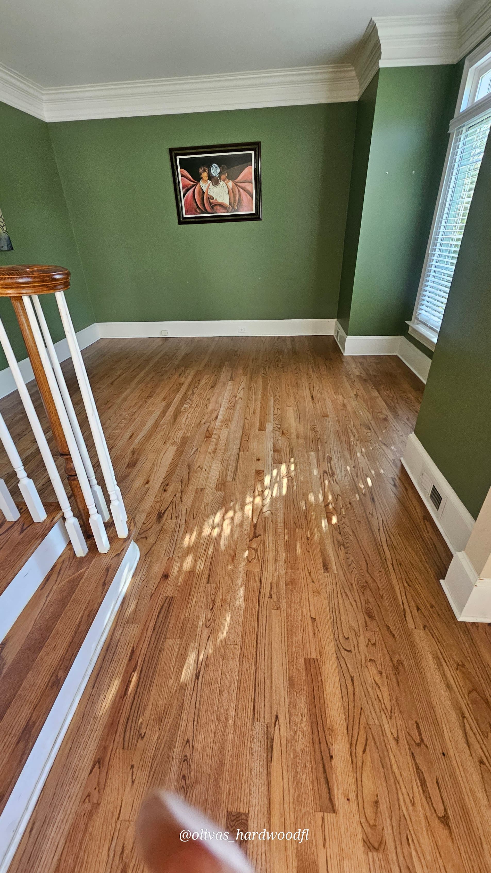 Hardwood floor refinishing in Sandy Springs GA — natural honey oak living room with green walls