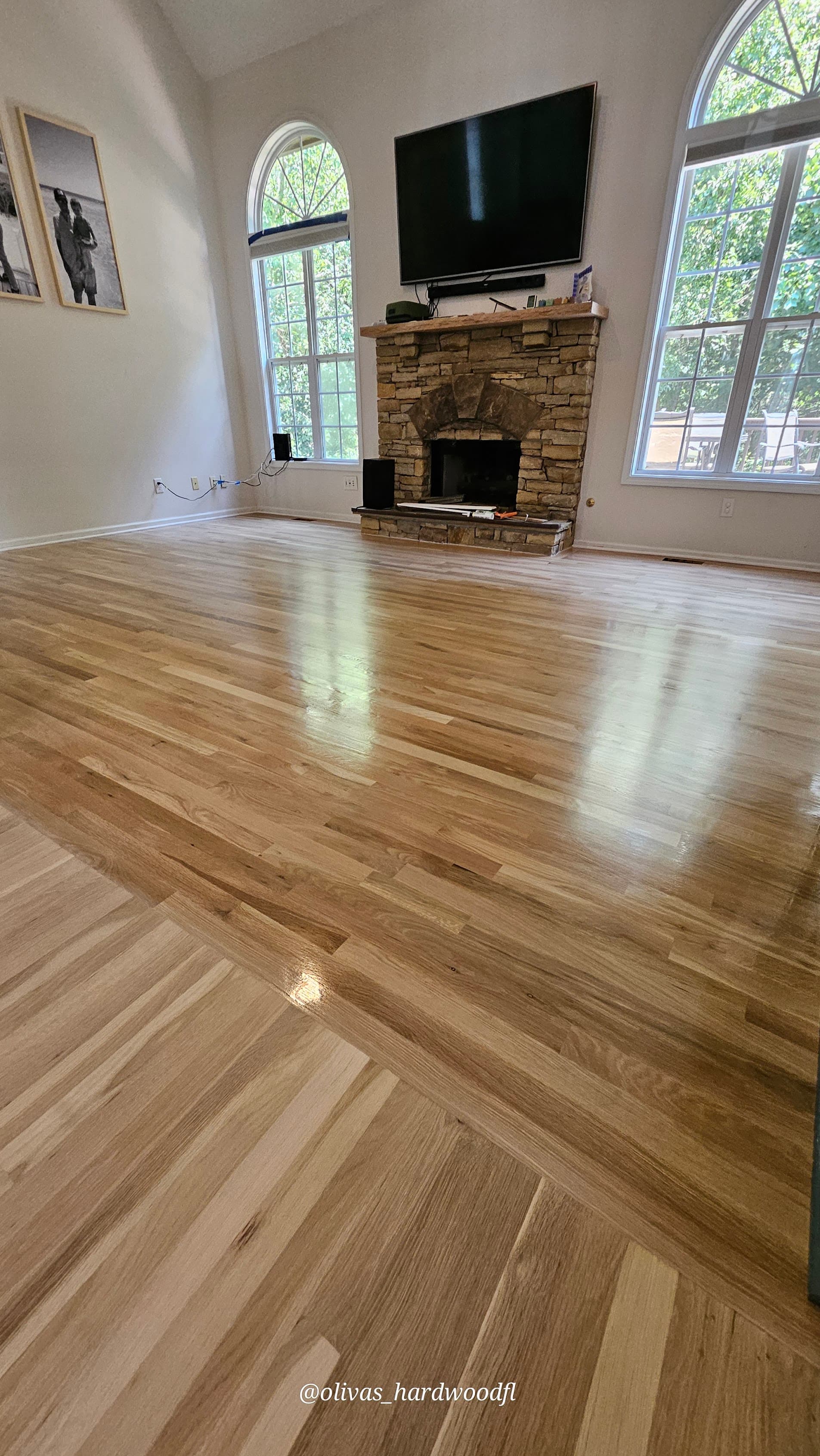 Hardwood floor refinishing in Marietta GA — natural honey oak high-gloss living room with stone fireplace