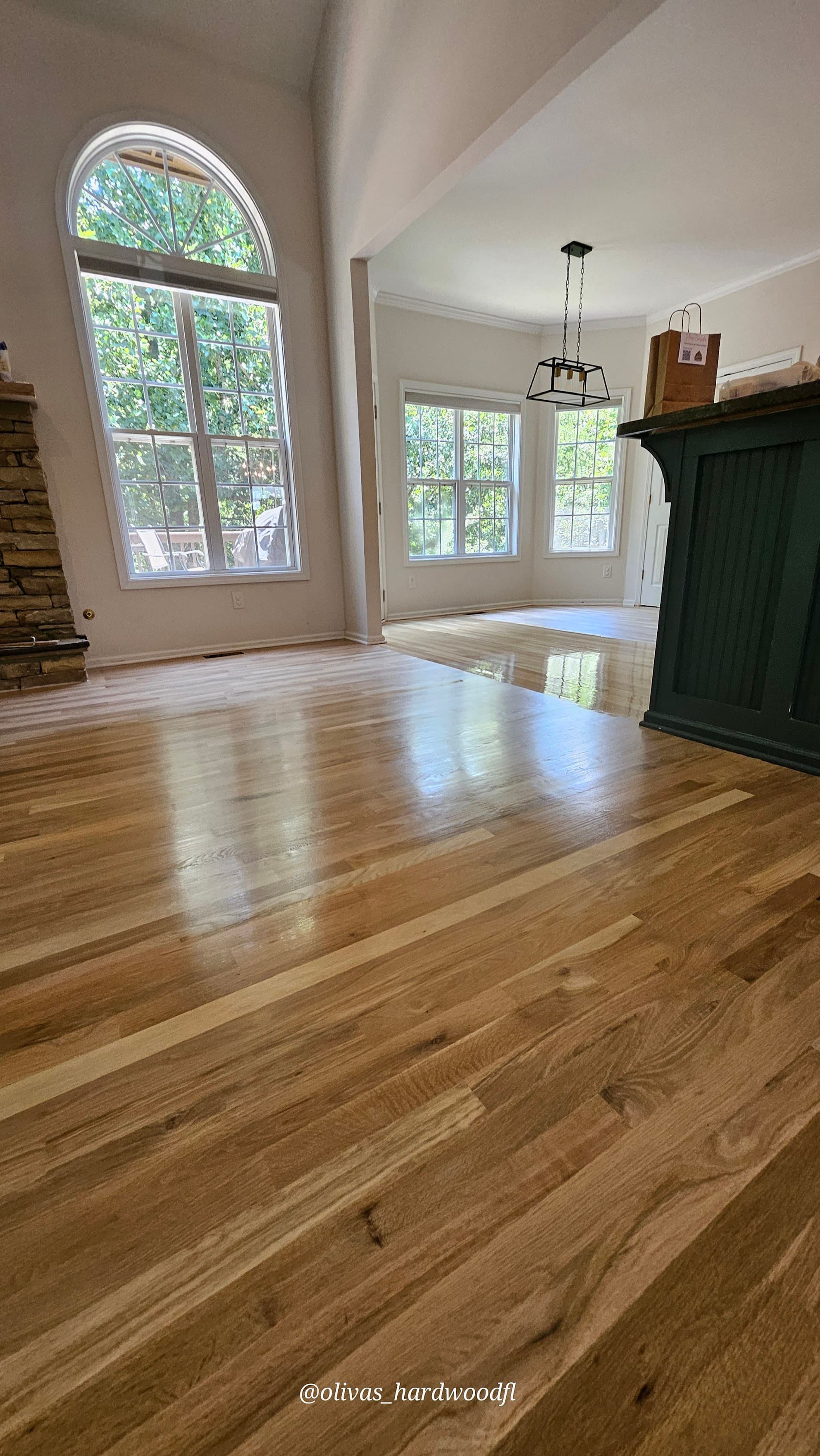 Hardwood floor refinishing in Alpharetta GA — natural honey oak high-gloss open living and kitchen with green cabinet