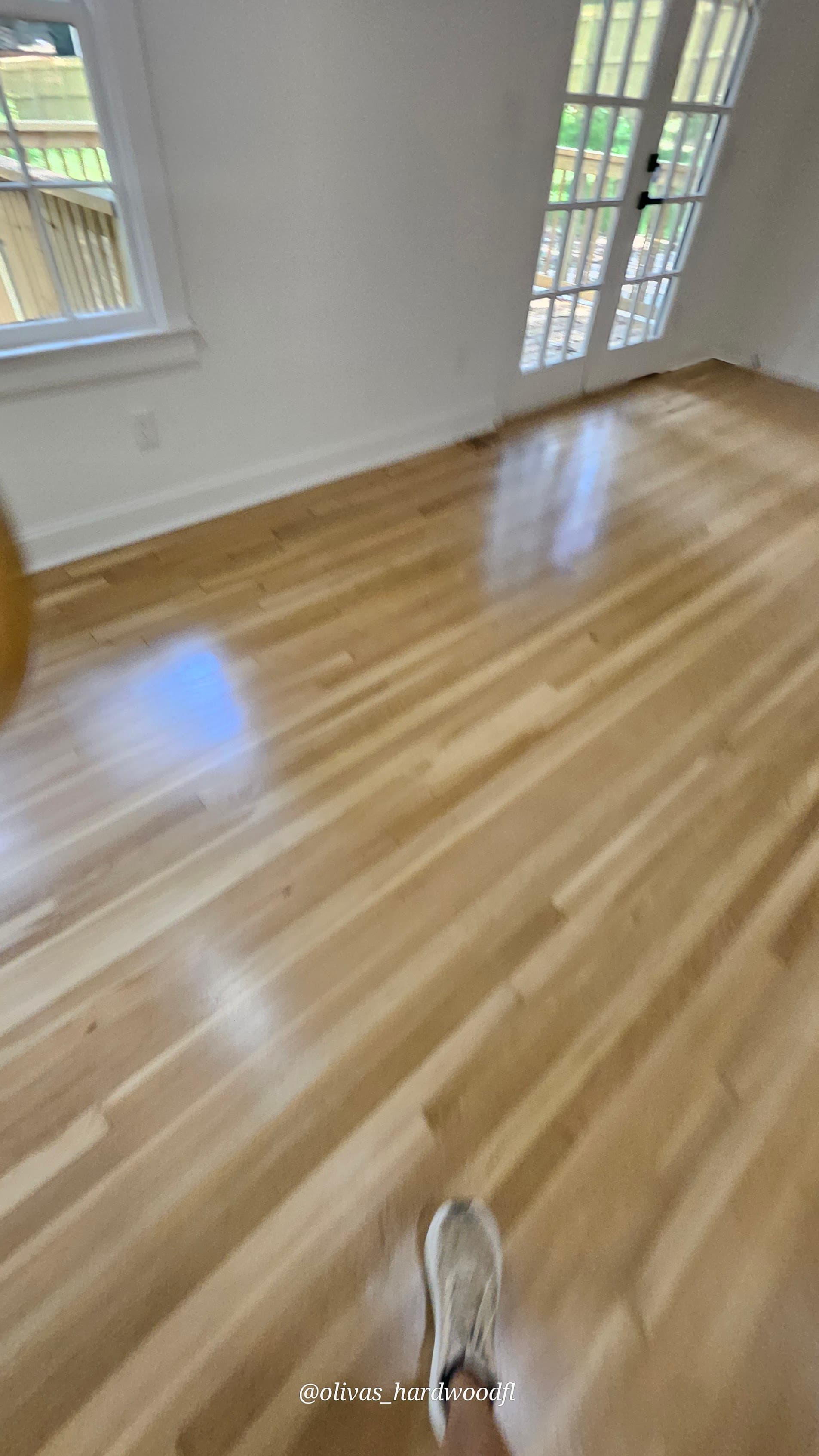 Hardwood floor refinishing in Duluth GA — natural light oak high-gloss bedroom with French doors