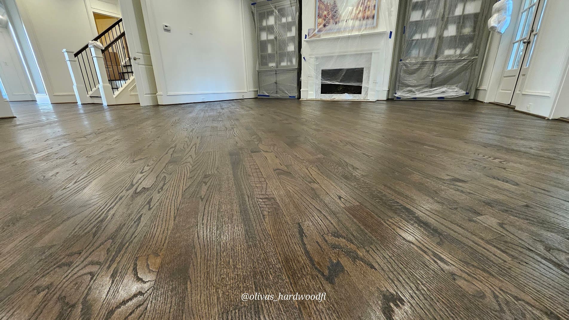Hardwood floor refinishing in Lawrenceville GA — charcoal gray custom stain on red oak living room with fireplace