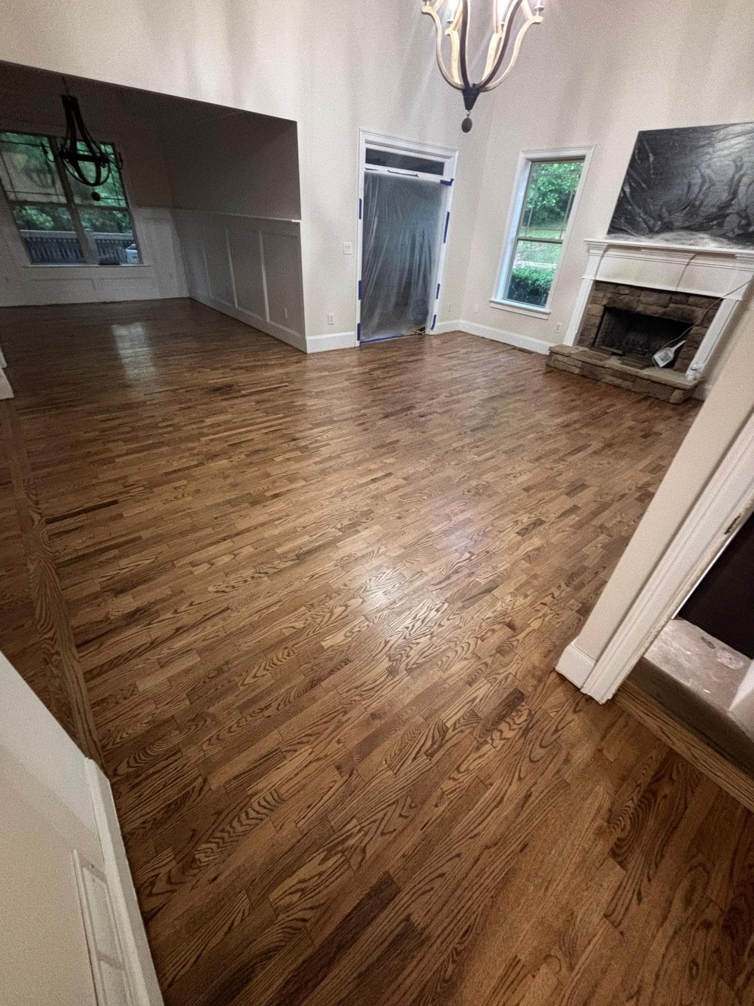 Hardwood floor refinishing in Marietta GA — medium brown stain oak living room with stone fireplace