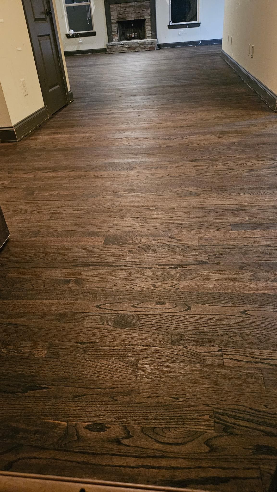 Hardwood floor refinishing in Lawrenceville GA — dark espresso oak living room with stone fireplace