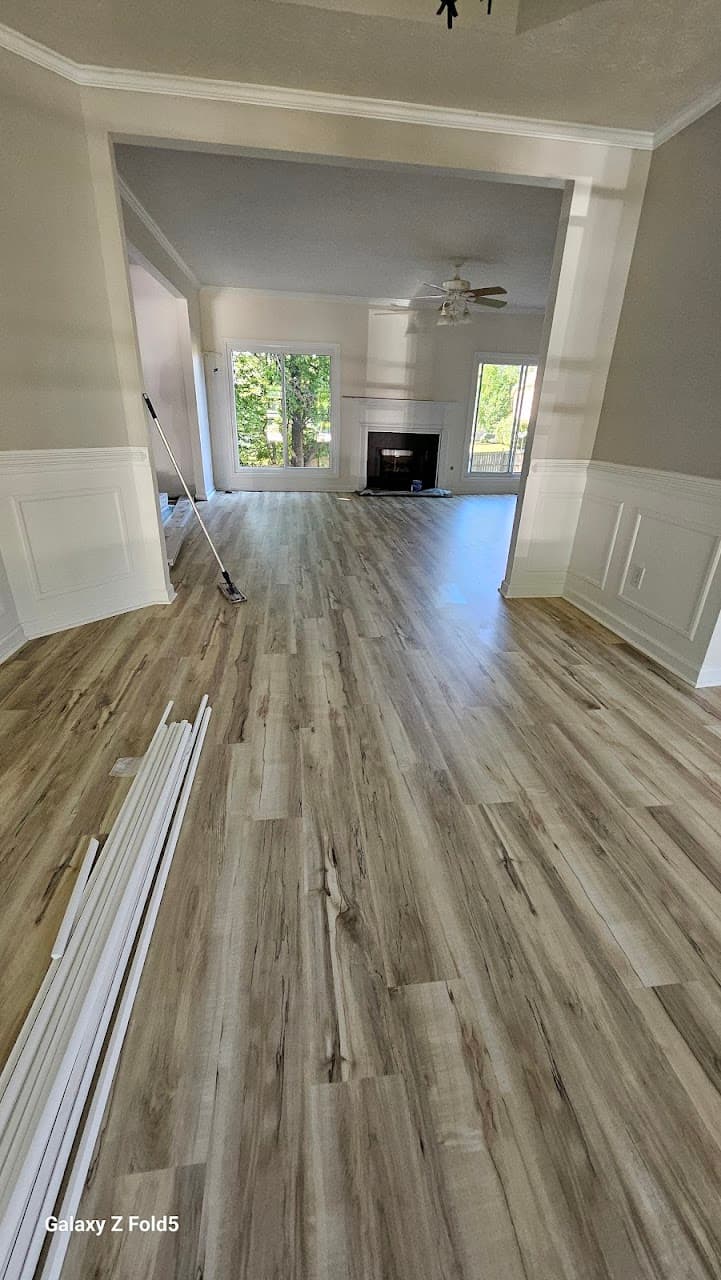 Luxury vinyl plank flooring in Duluth GA — light gray-oak LVP in open living and dining room with wainscoting