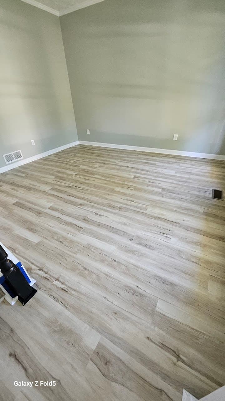 Luxury vinyl plank flooring in Atlanta GA — light gray-oak LVP in bedroom with sage green walls