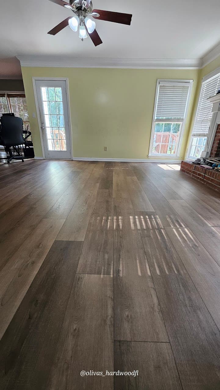 Luxury vinyl plank flooring in Atlanta GA — gray-brown LVP in living room with brick fireplace and yellow walls