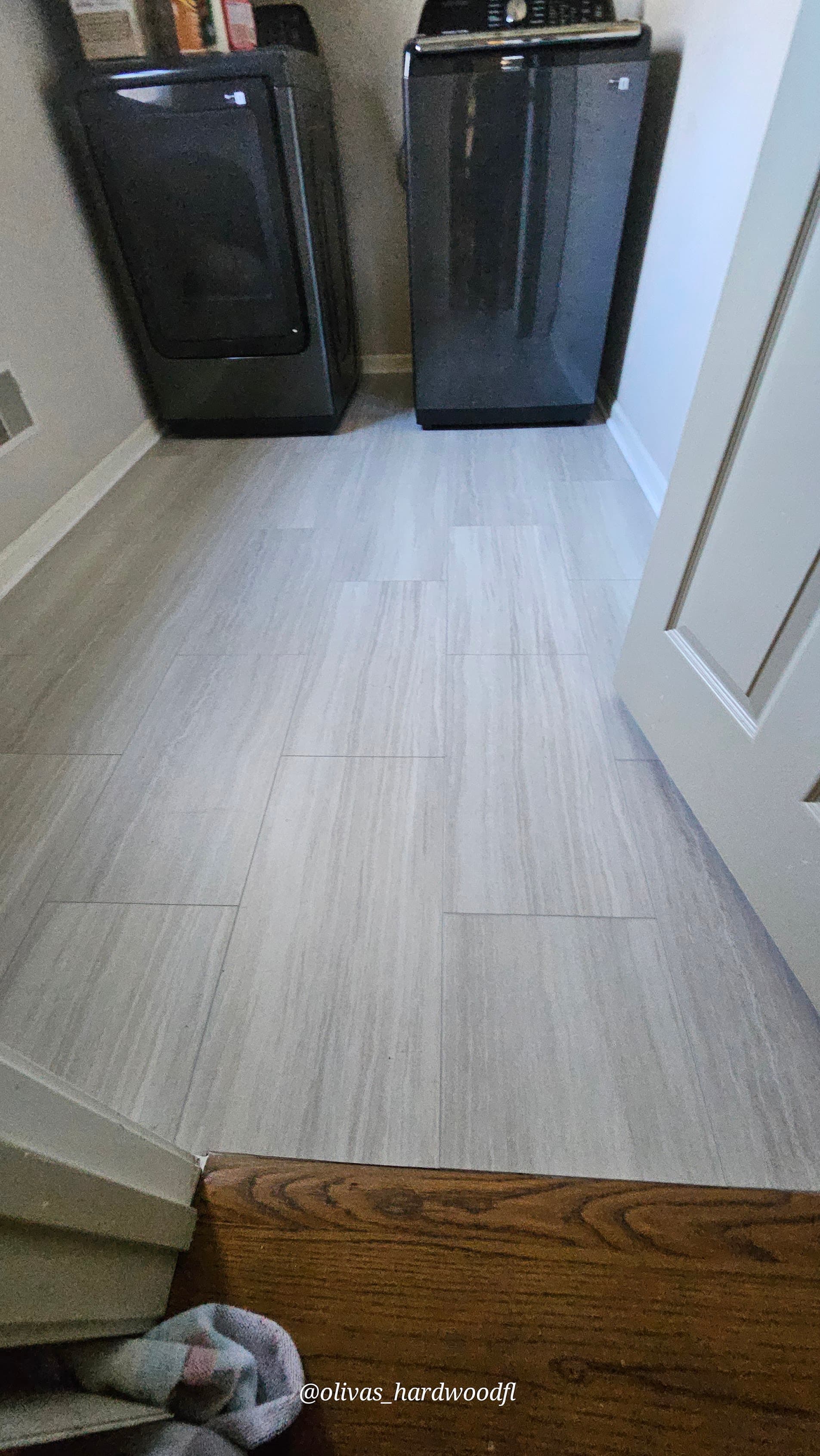 Luxury vinyl tile flooring in Gwinnett County GA — stone-look LVT laundry room with hardwood transition