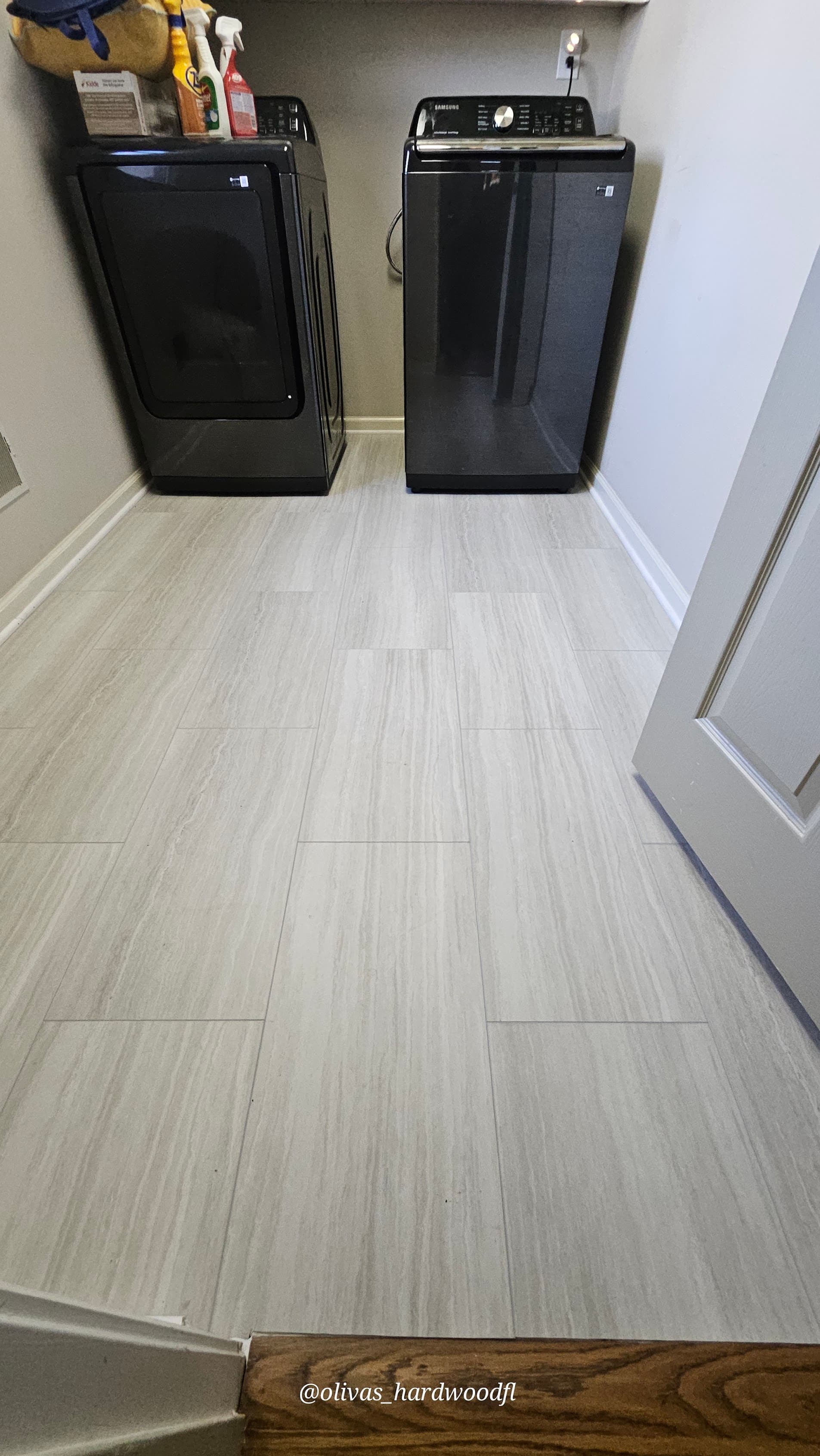 Luxury vinyl tile flooring in Atlanta GA — stone-look LVT laundry room with oak threshold