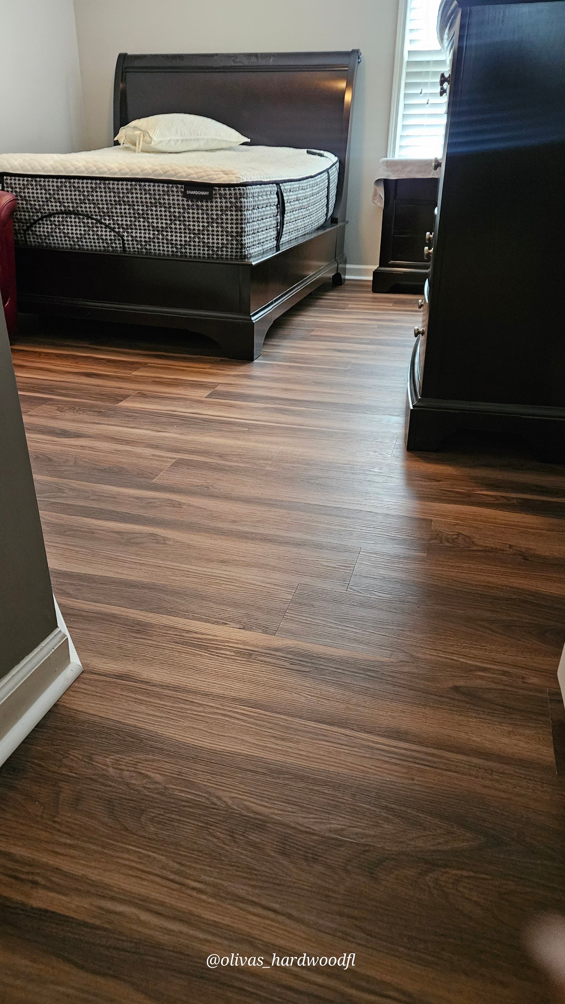 Luxury vinyl plank flooring in Lawrenceville GA — dark walnut LVP installed in bedroom