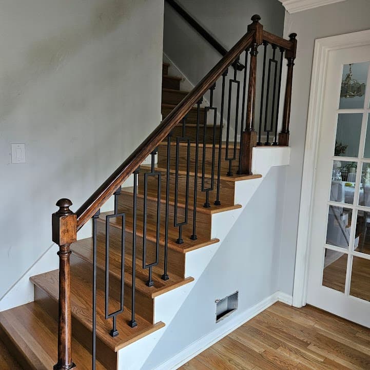 Staircase renovation in Johns Creek GA — natural oak treads with dark stained handrail and modern rectangular iron balusters