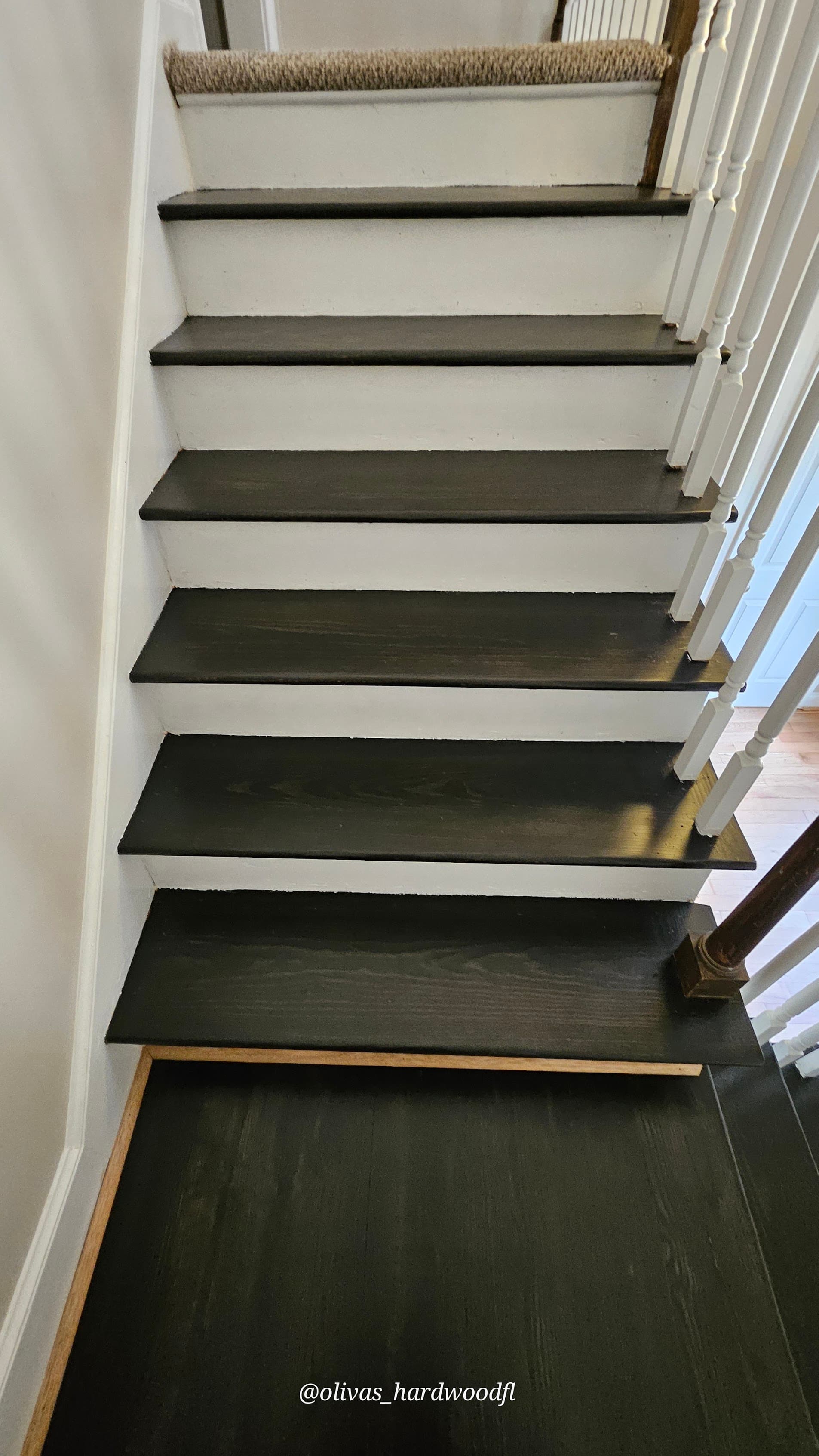 Staircase renovation in Gwinnett County GA — dark ebony stain oak treads with white painted risers and spindles