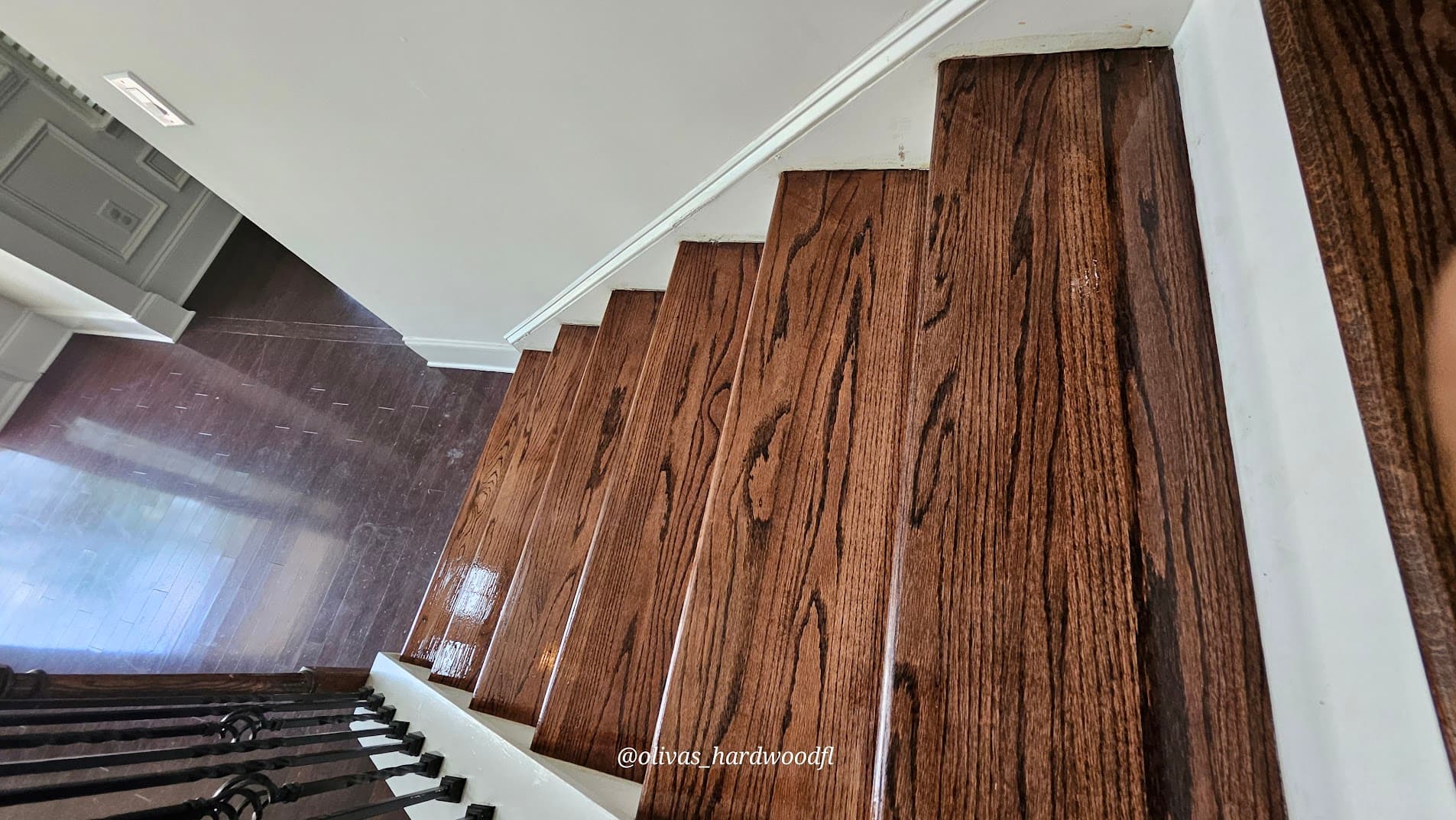 Staircase renovation in Atlanta GA — top-down view of dark espresso oak treads with iron balusters