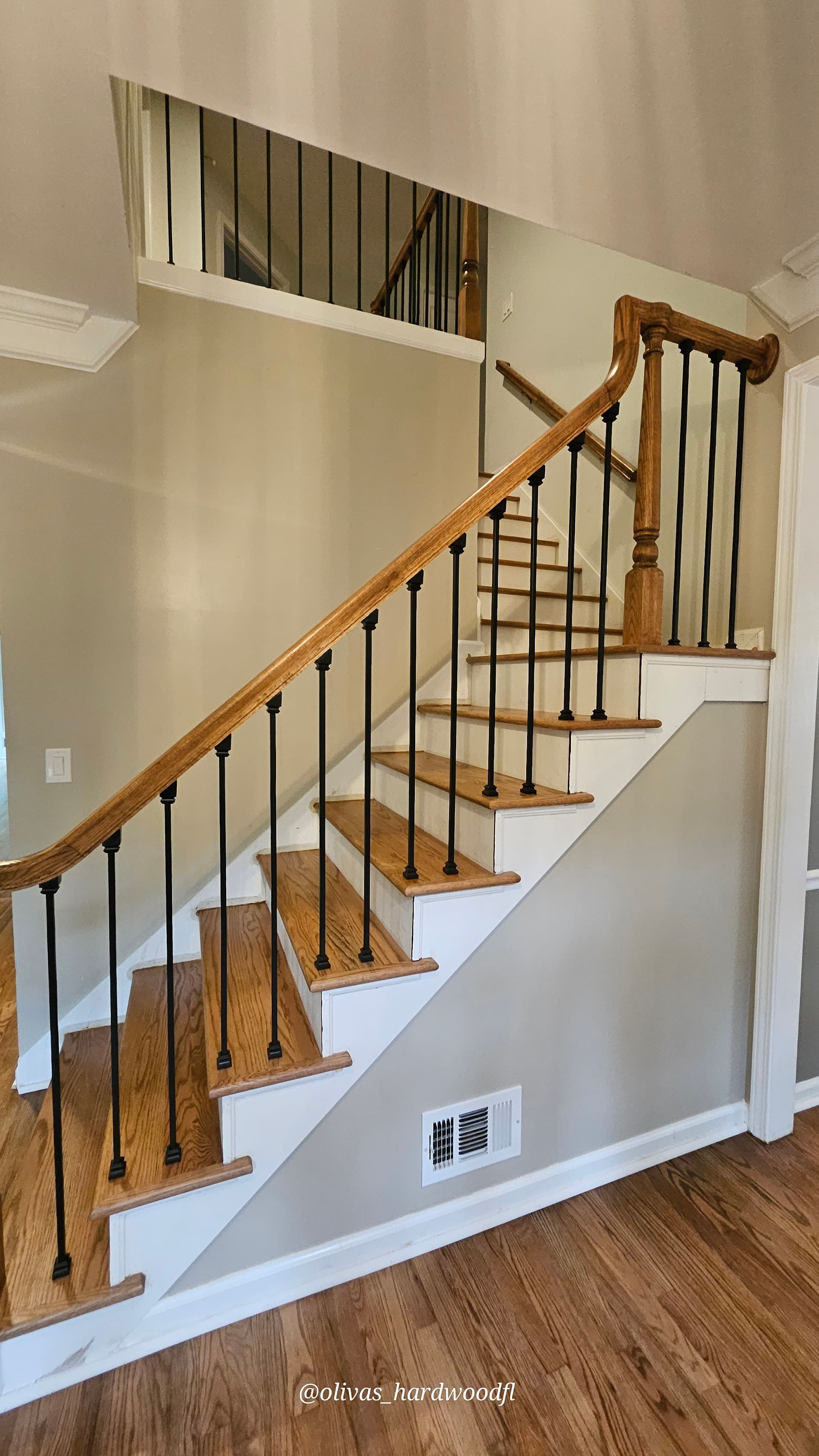 Staircase renovation in Gwinnett County GA — natural oak treads with iron balusters open staircase view