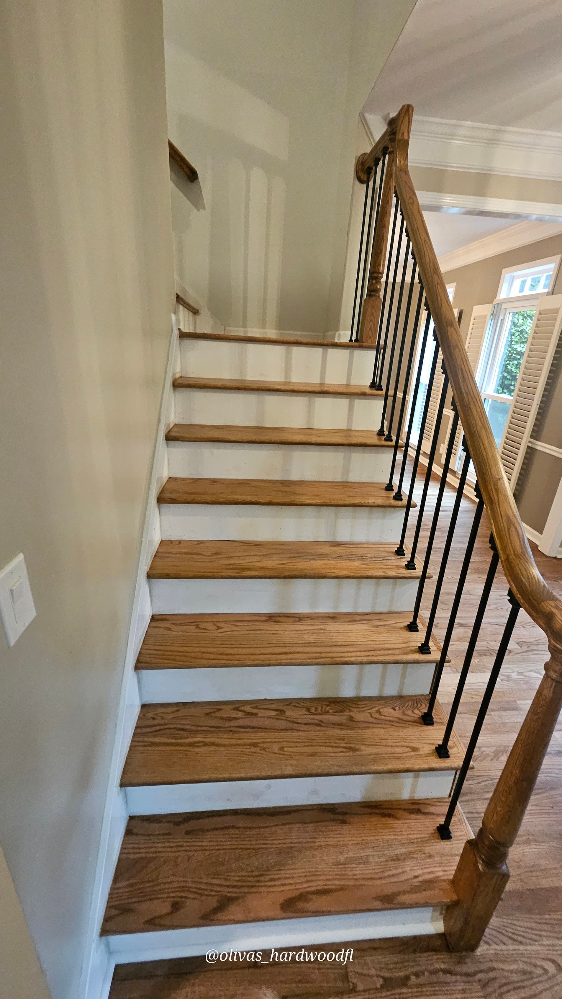 Staircase renovation in Duluth GA — natural oak treads with iron balusters side view