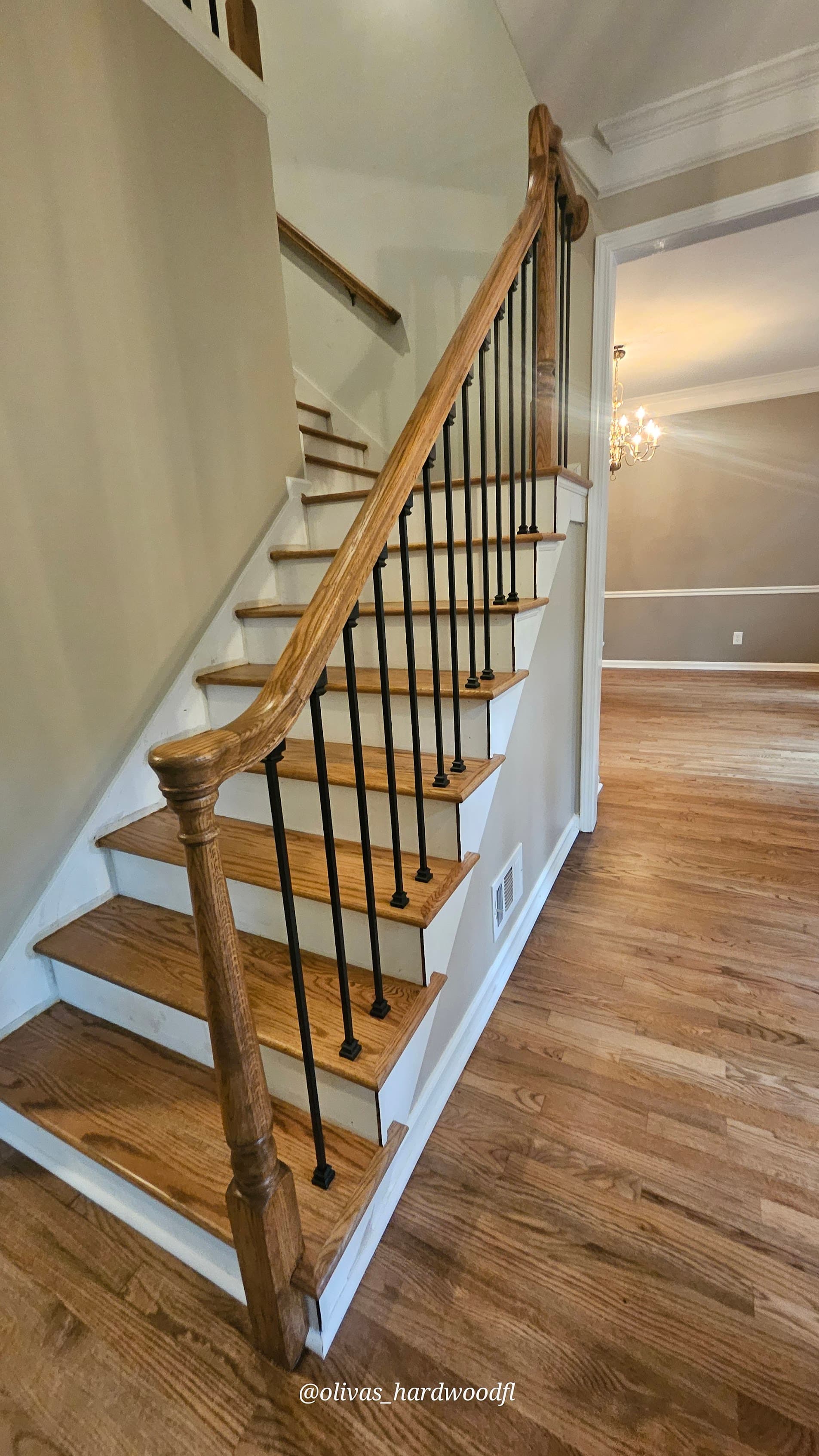 Staircase renovation in Roswell GA — natural oak treads with iron balusters complementing hardwood floors