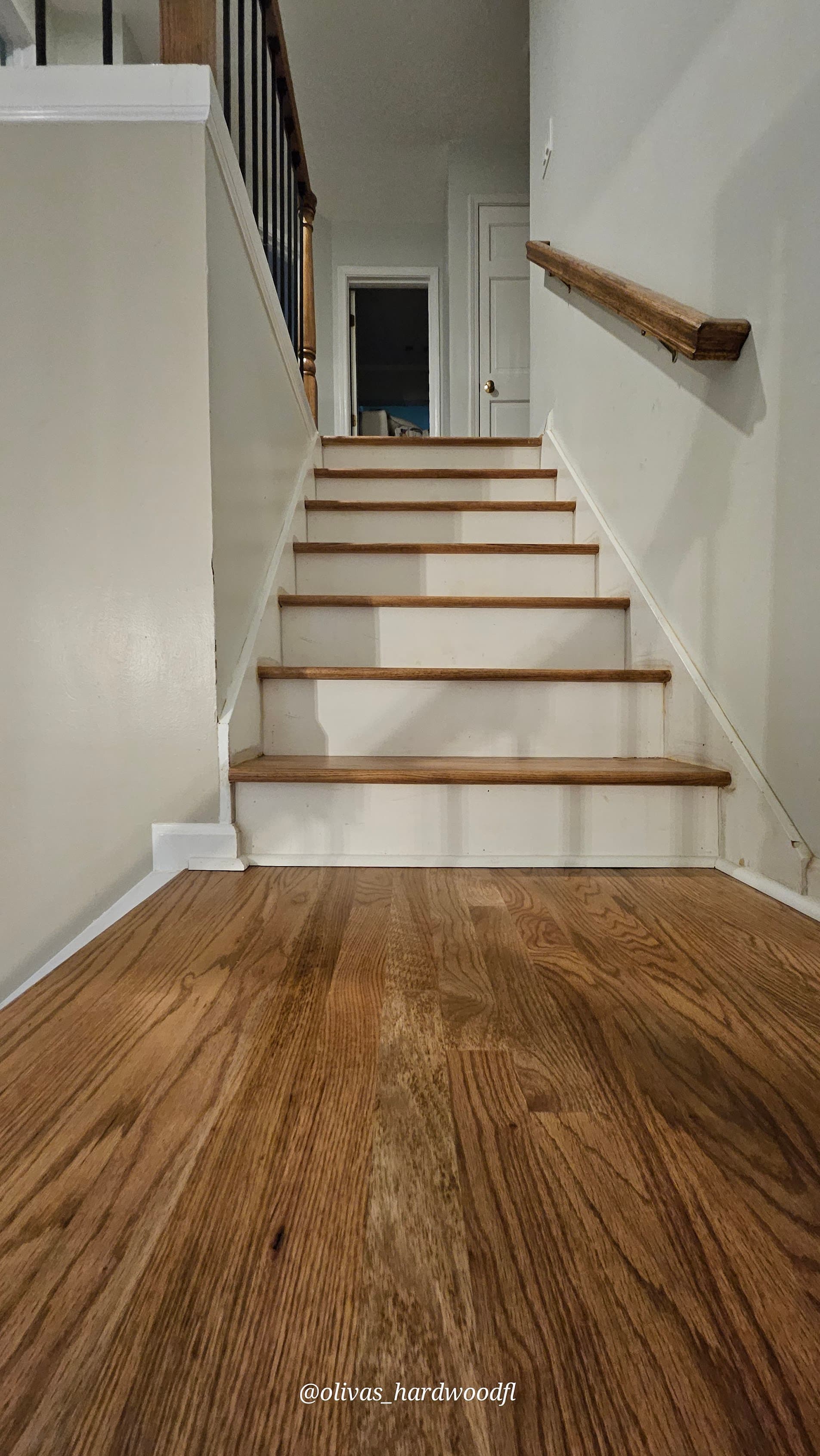 Staircase renovation in Alpharetta GA — medium stain oak treads with white risers over hardwood floors