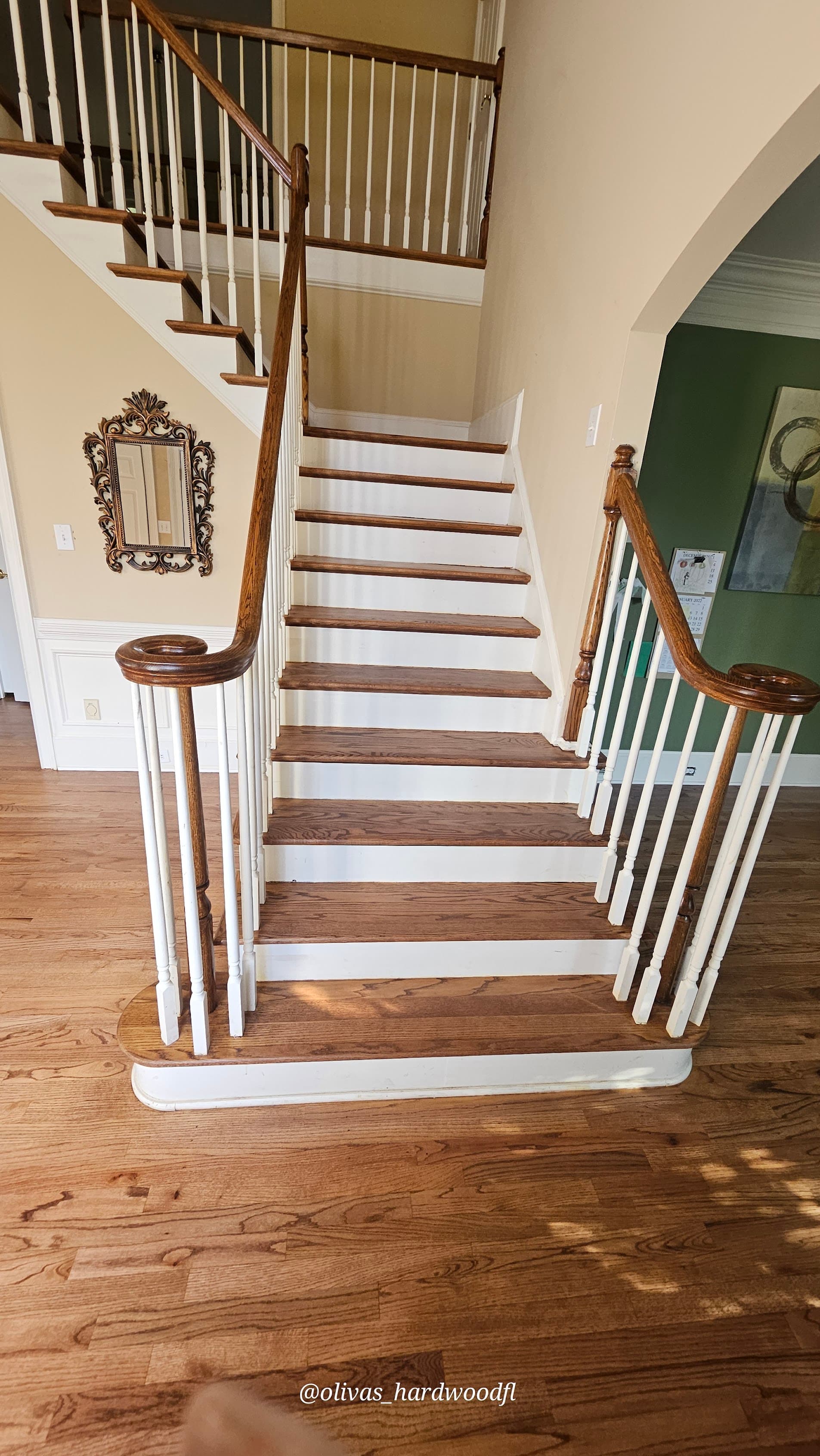 Grand staircase renovation in Gwinnett County GA — medium stain oak treads with white painted spindles