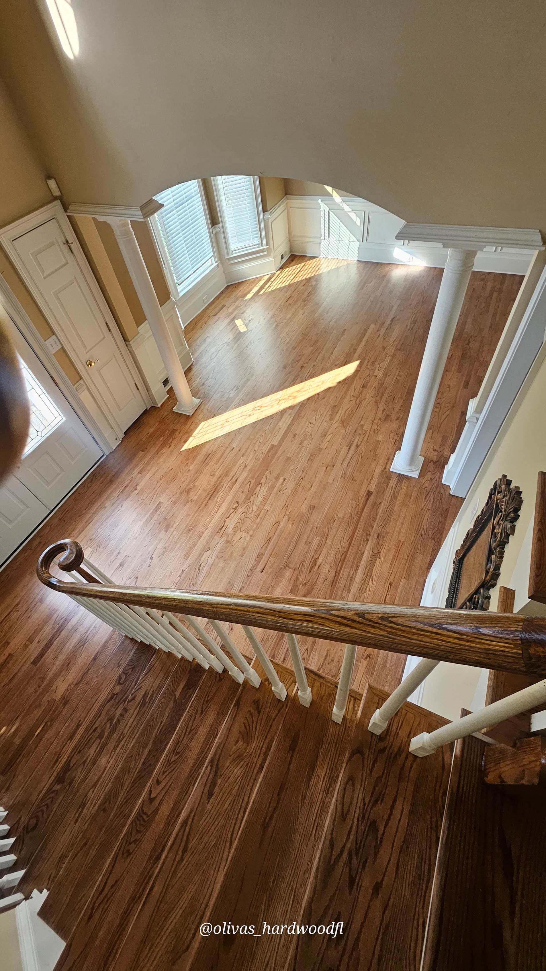 Staircase renovation in Marietta GA — bird's eye view of grand foyer with oak treads and white columns