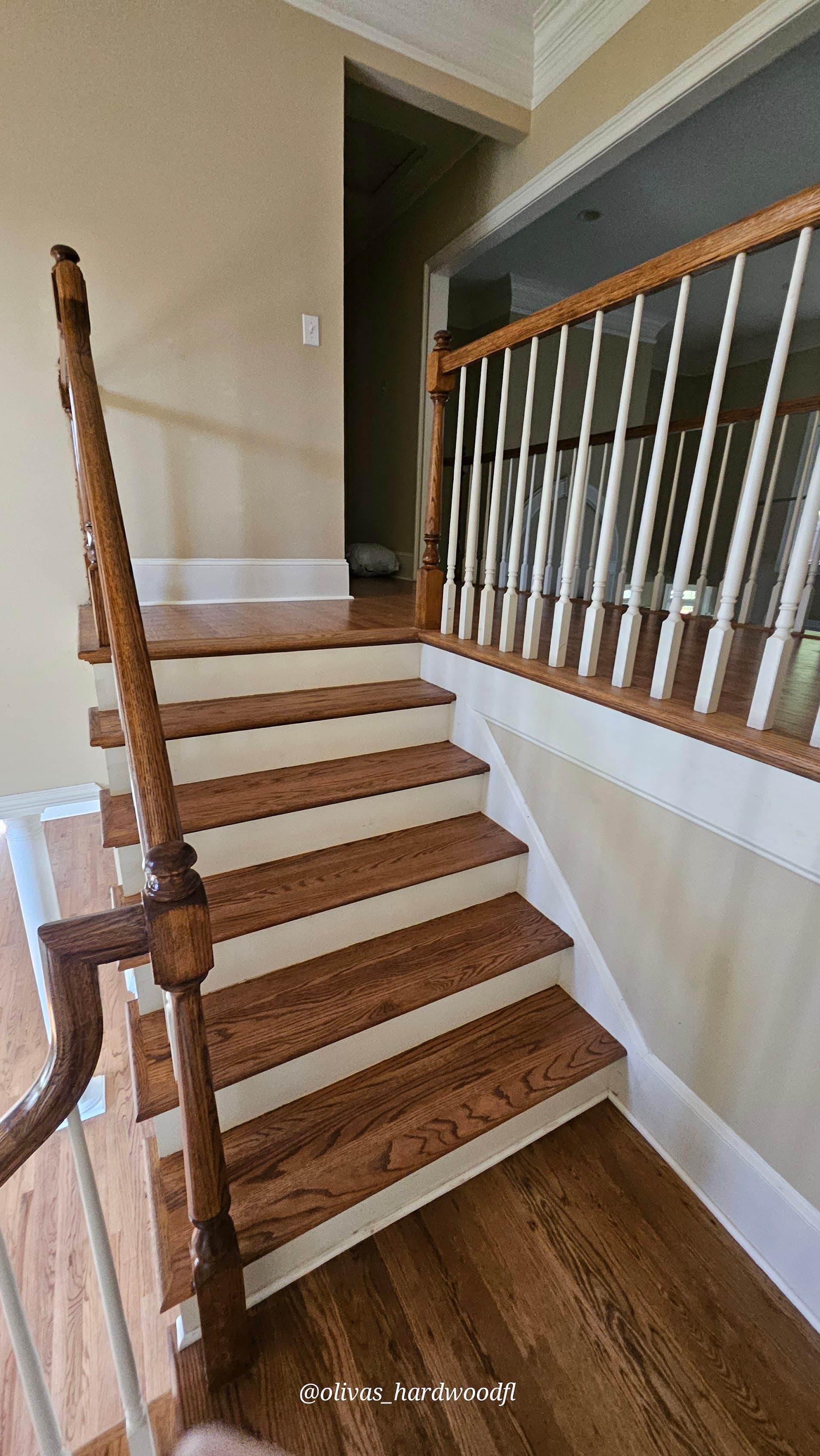 Curved staircase renovation in Atlanta GA — medium stain oak treads with white painted spindles