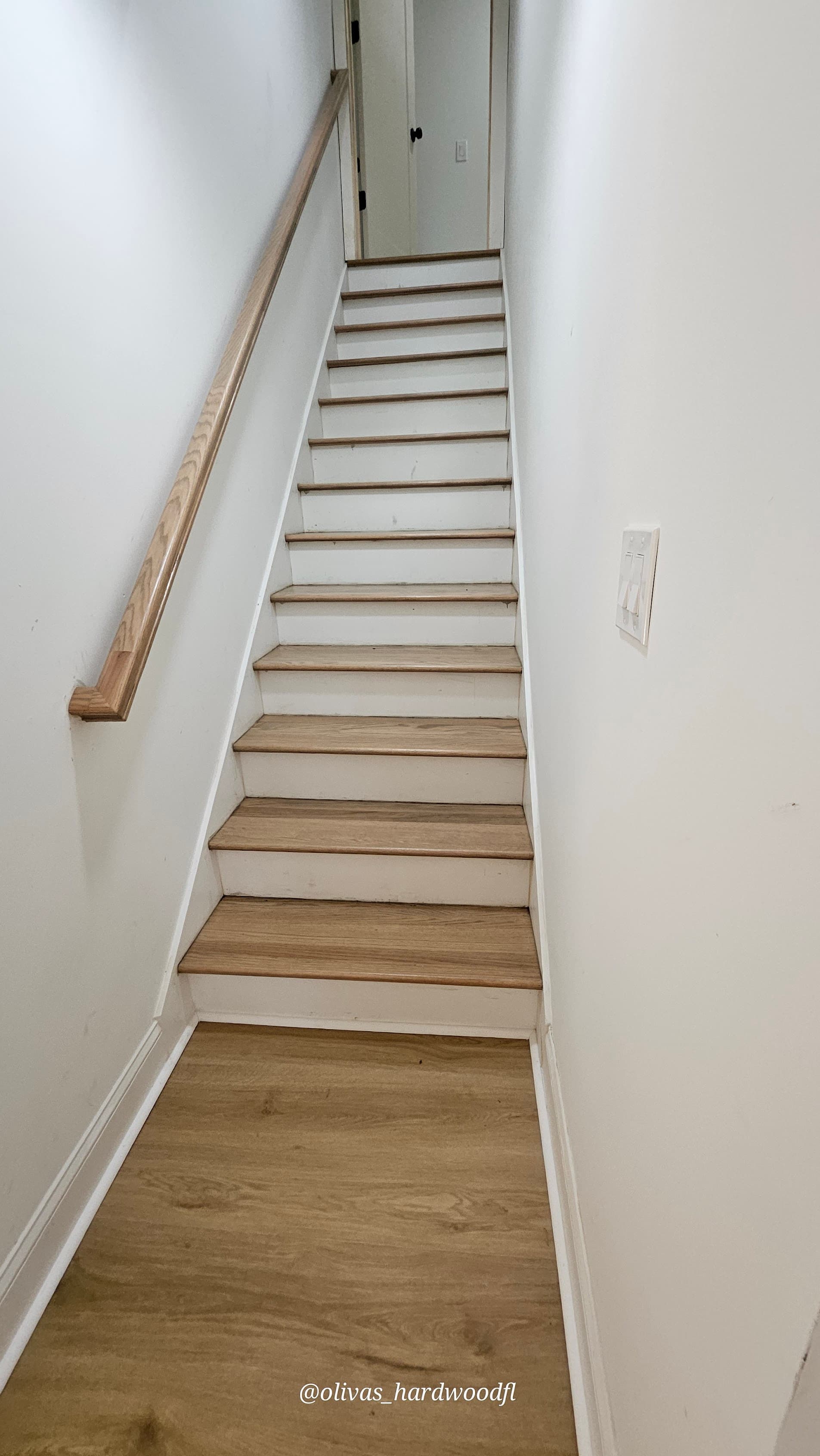 Staircase renovation in Marietta GA — luxury vinyl plank treads with white risers and simple handrail