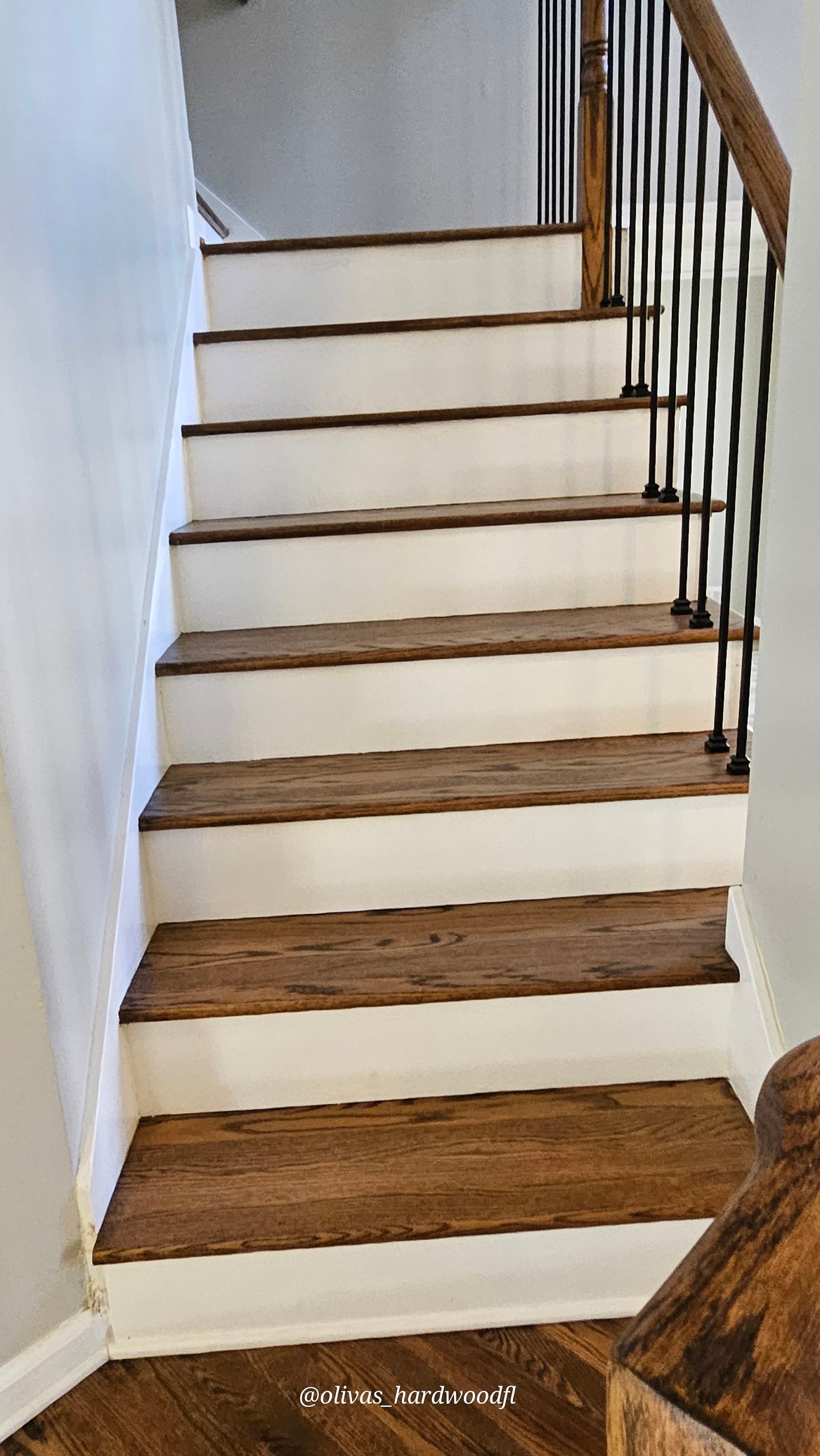 Staircase renovation in Atlanta GA — dark stain oak treads with white risers and iron balusters