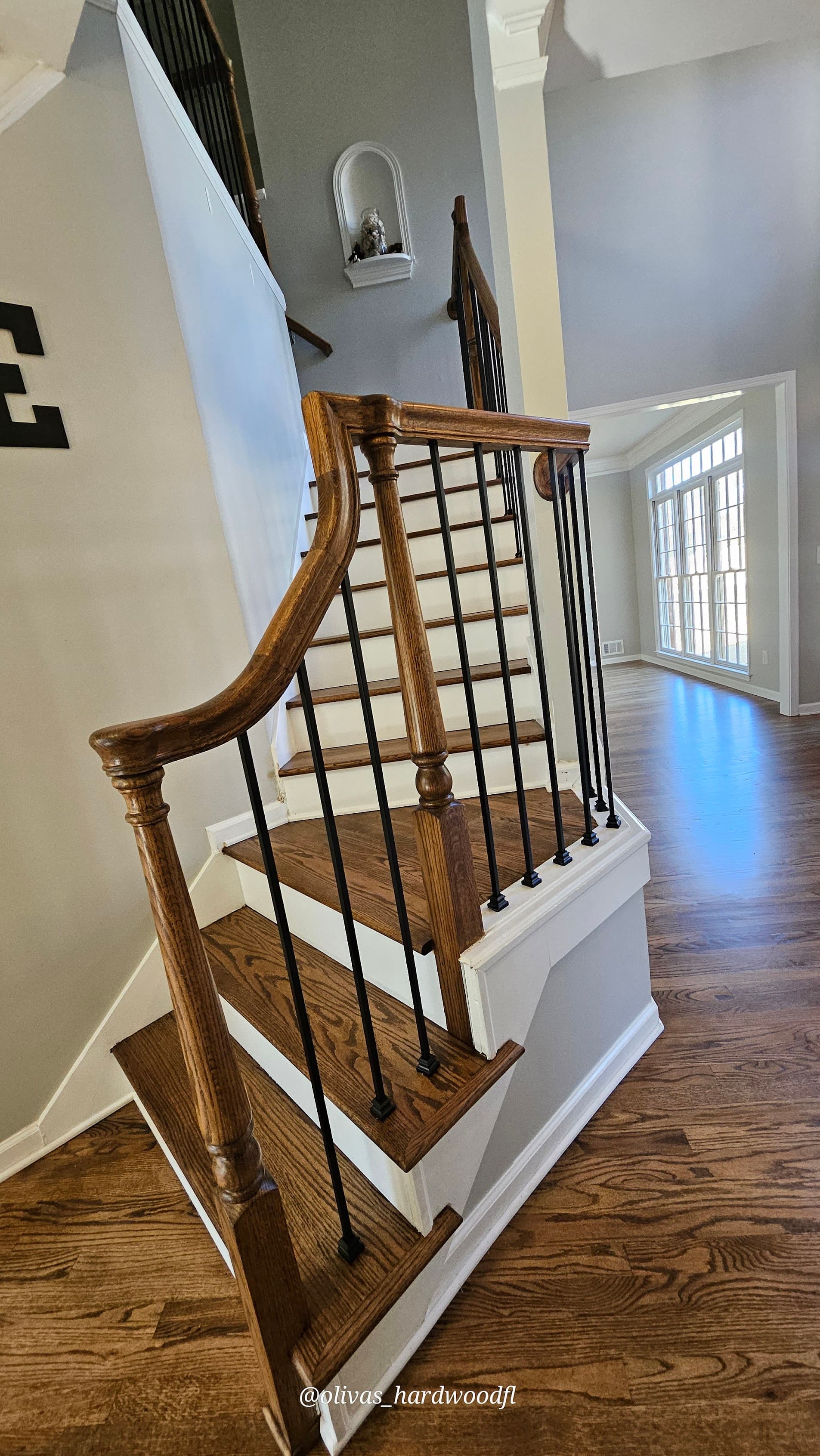 Staircase renovation in Gwinnett County GA — dark stain oak treads with wrought iron balusters